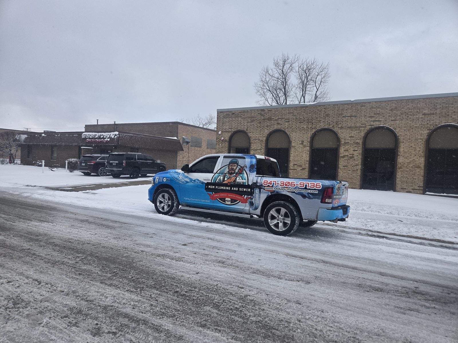 MDM Plumbing pickup truck on a snowy Chicagoland street — 24/7 emergency service